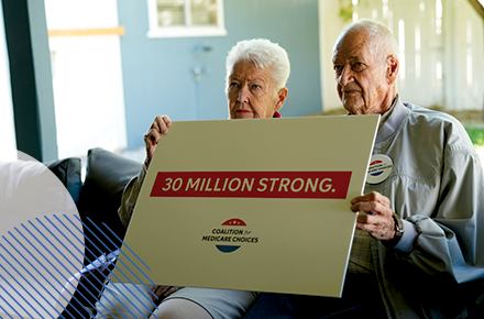 Two seniors holding a sign that emphasizes that 30 million people are enrolled in Medicare Advantage